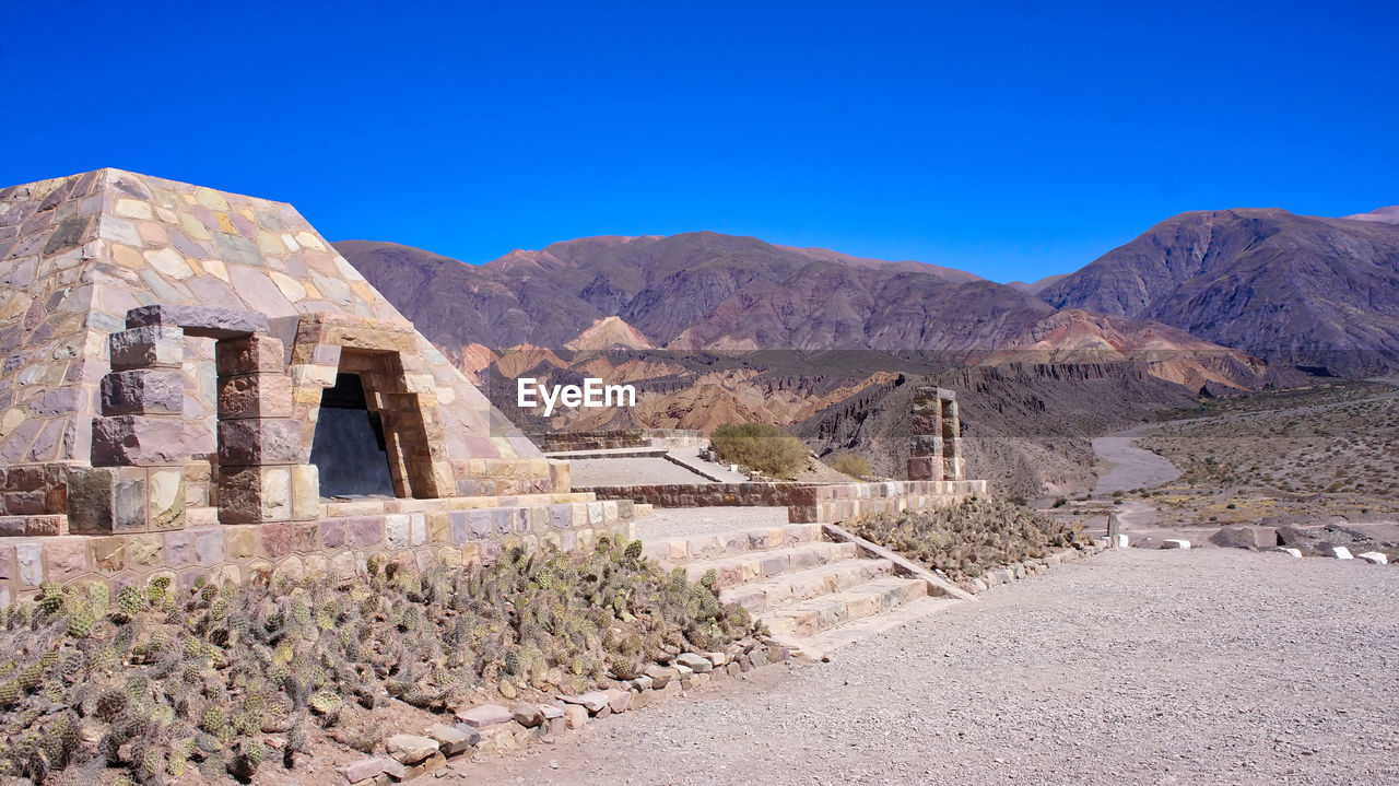 BUILT STRUCTURE ON MOUNTAIN AGAINST BLUE SKY