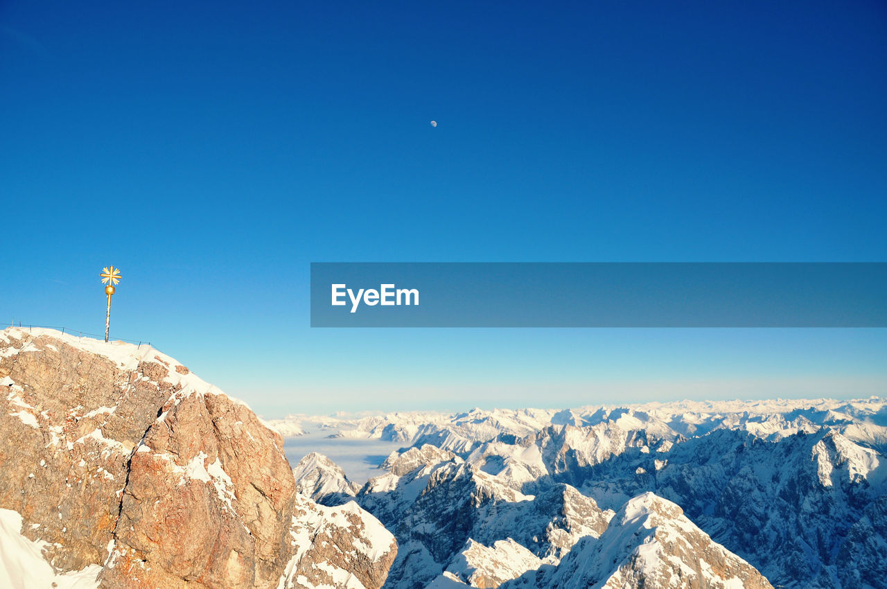 Summit cross on zugspitze mountain peak against clear sky