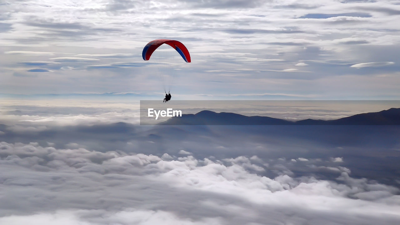 Person paragliding against sky