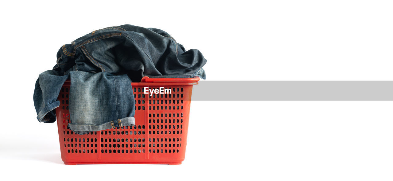 Close-up of clothes in basket against white background