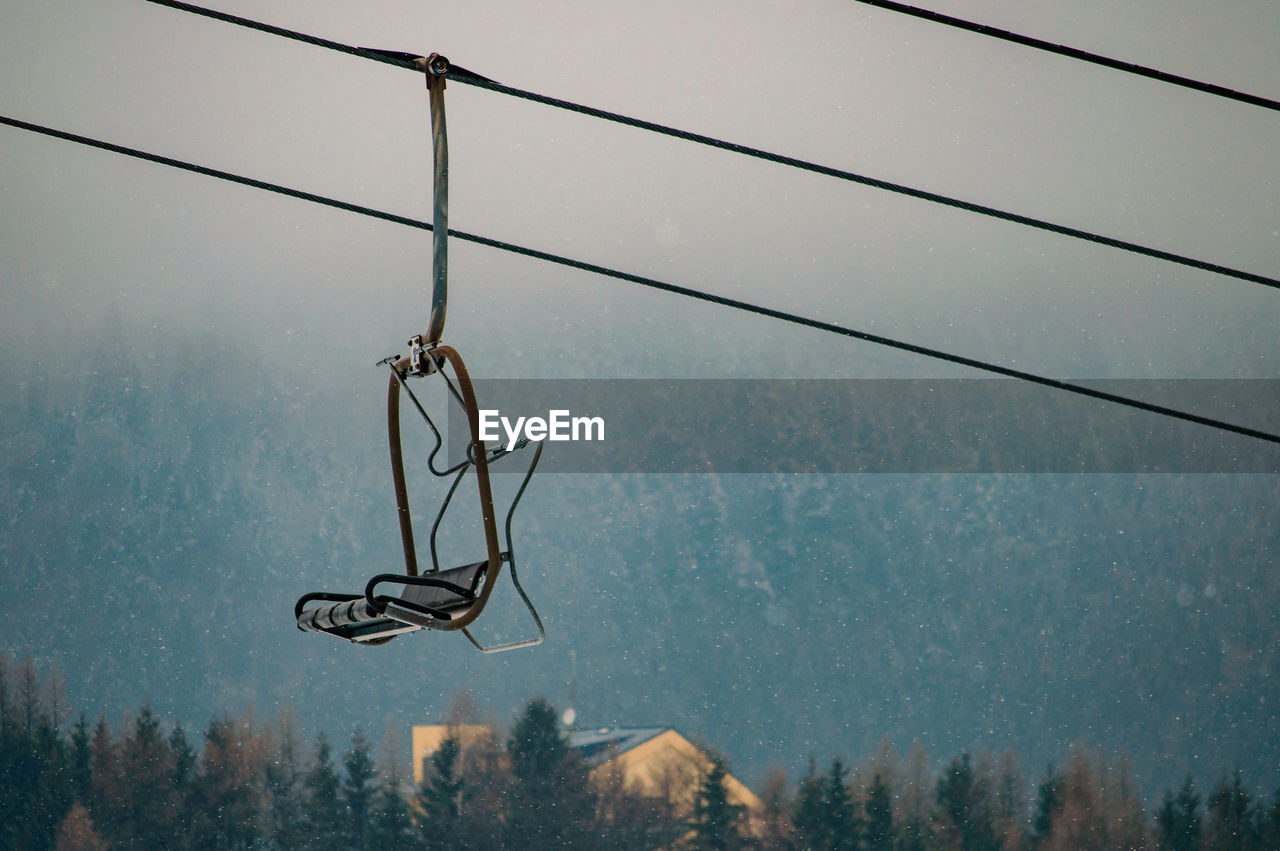 Low angle view of overhead cable car against sky