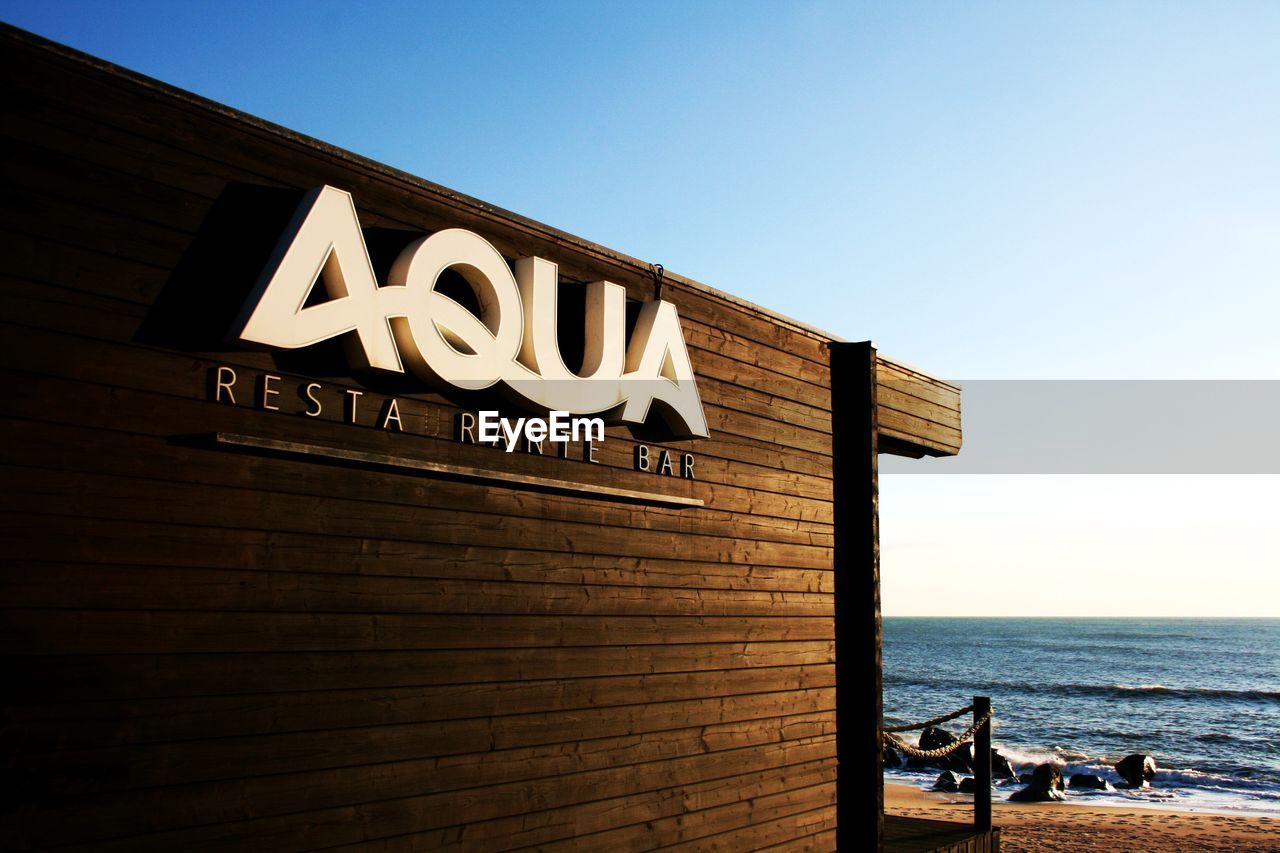 INFORMATION SIGN BY SEA AGAINST SKY