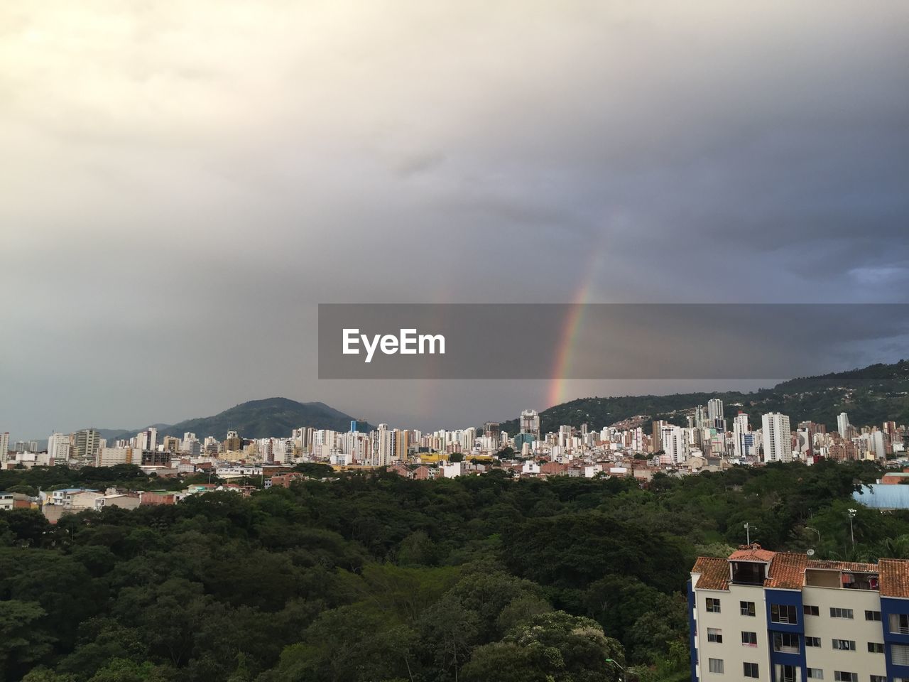 Scenic view of rainbow over town against sky