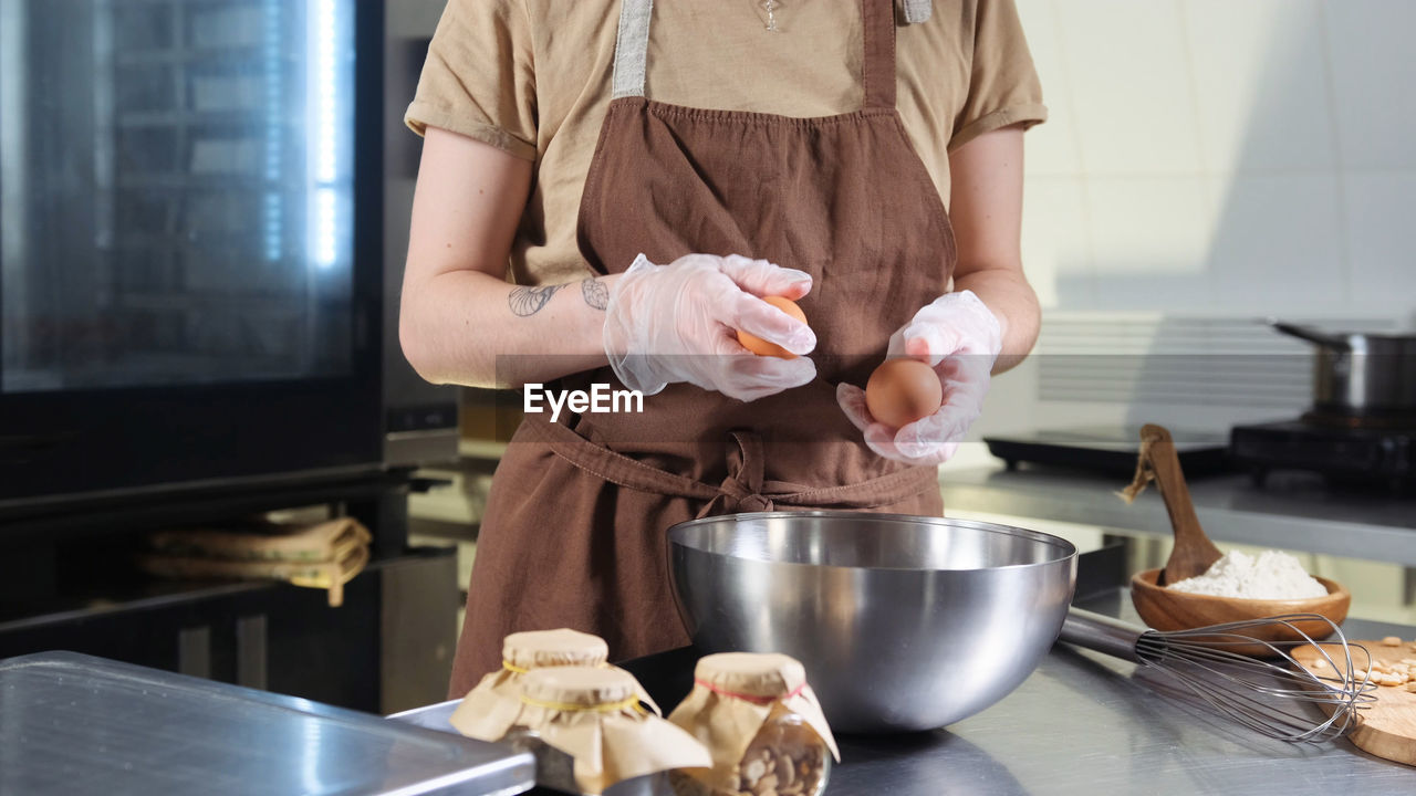 midsection of chef preparing food in kitchen at home