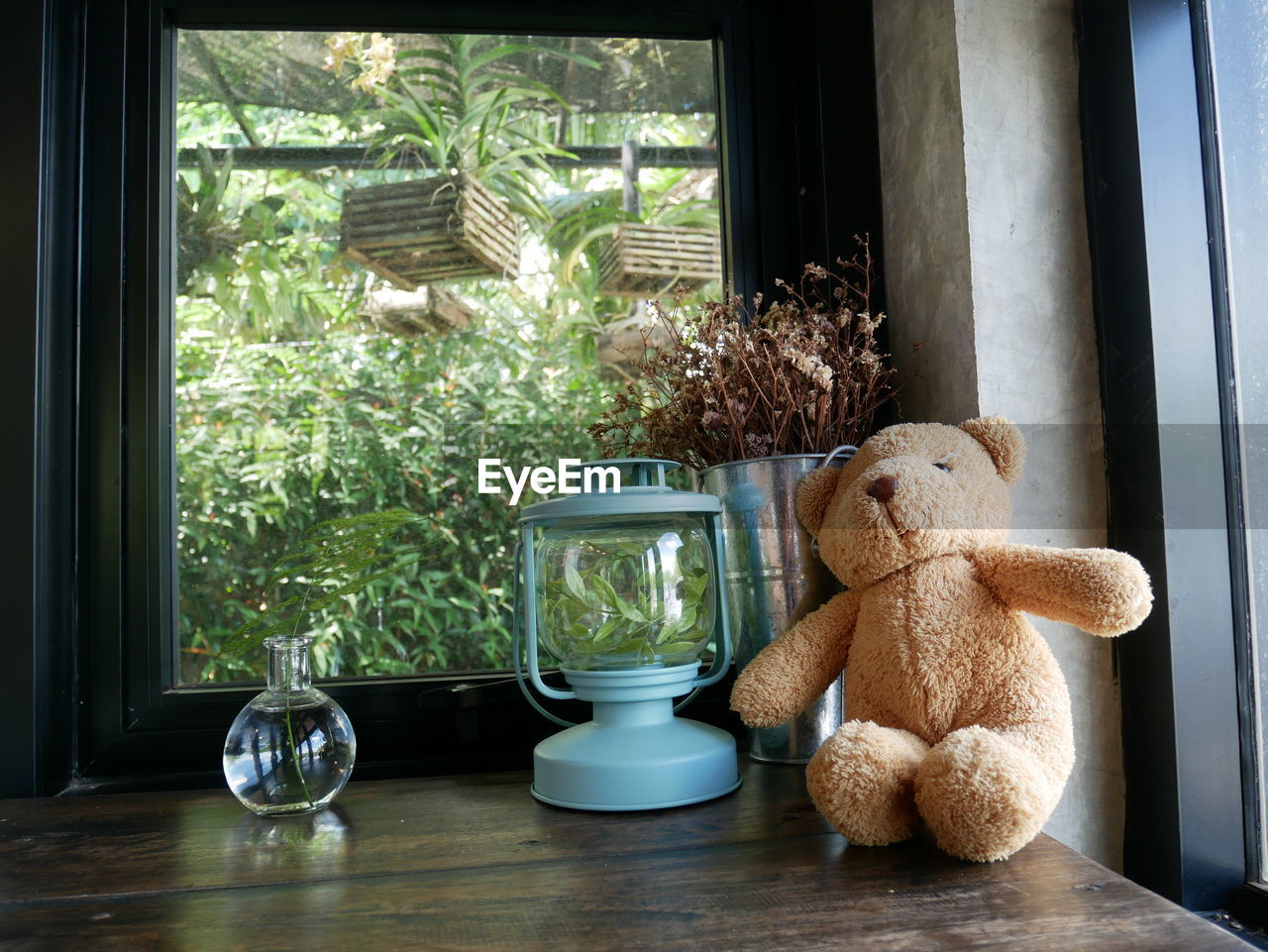 Teddy bear and lantern on table at home