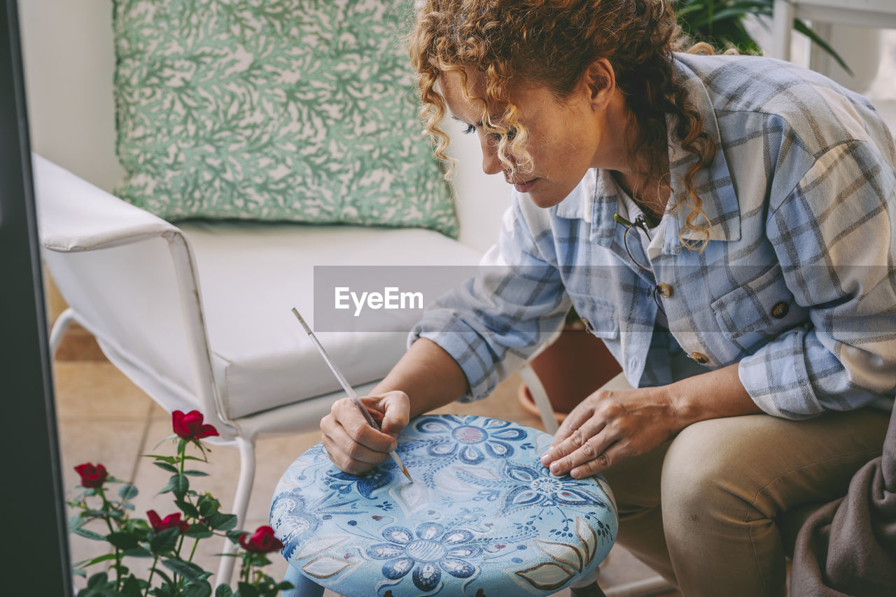 Mature woman drawing art on table