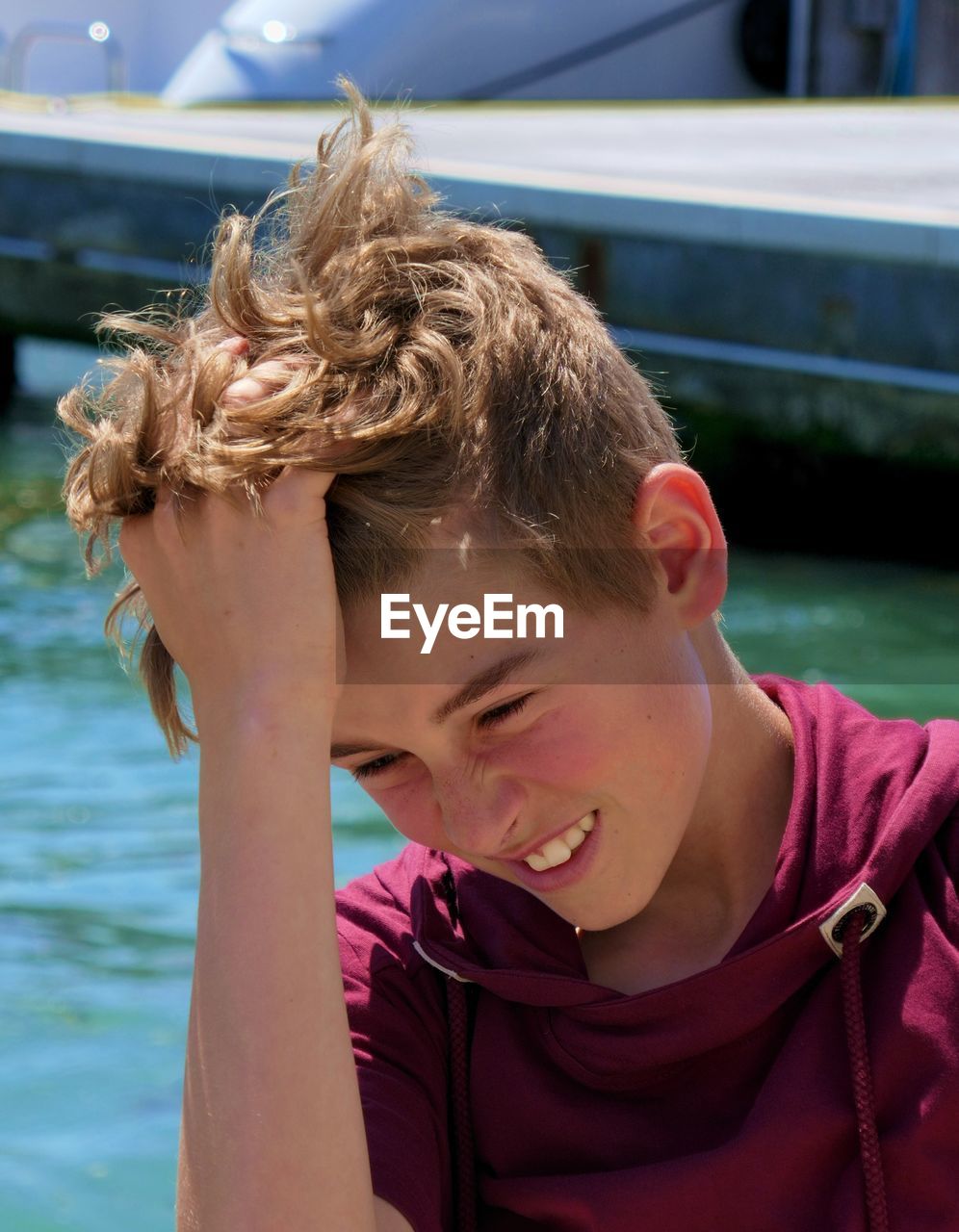 Close-up of smiling boy with hand in hair