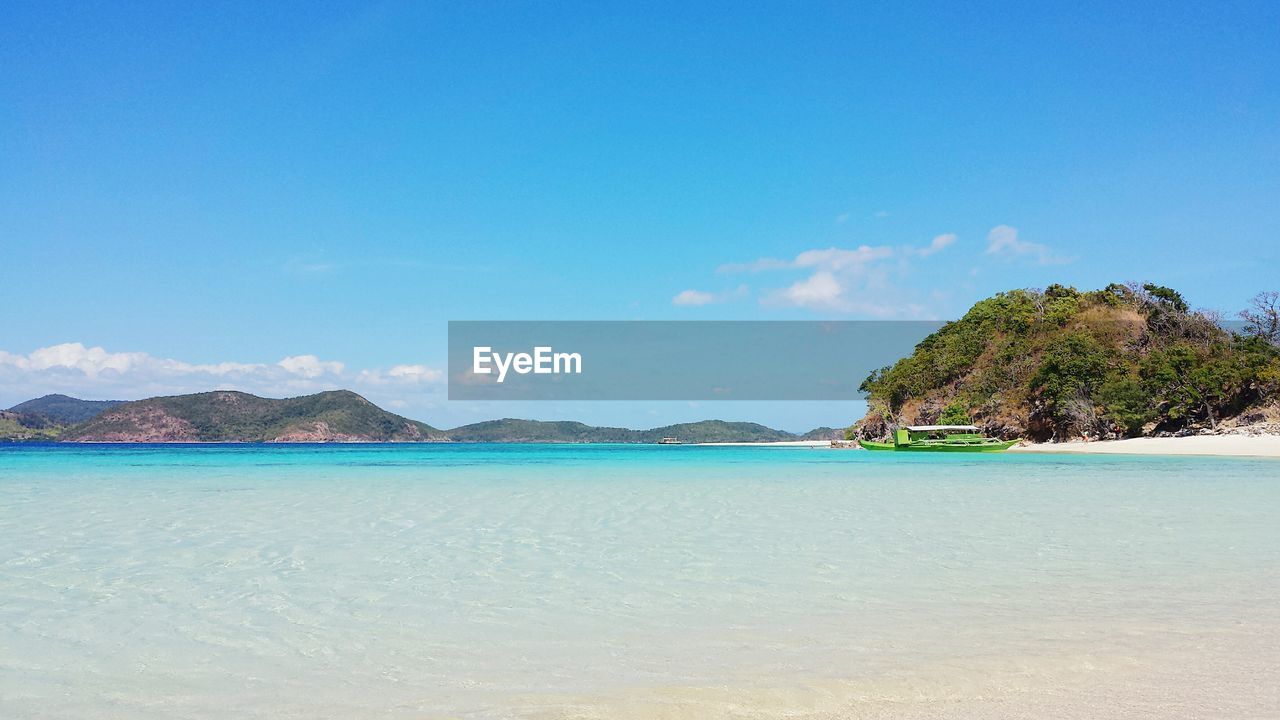 Scenic view of beach against blue sky