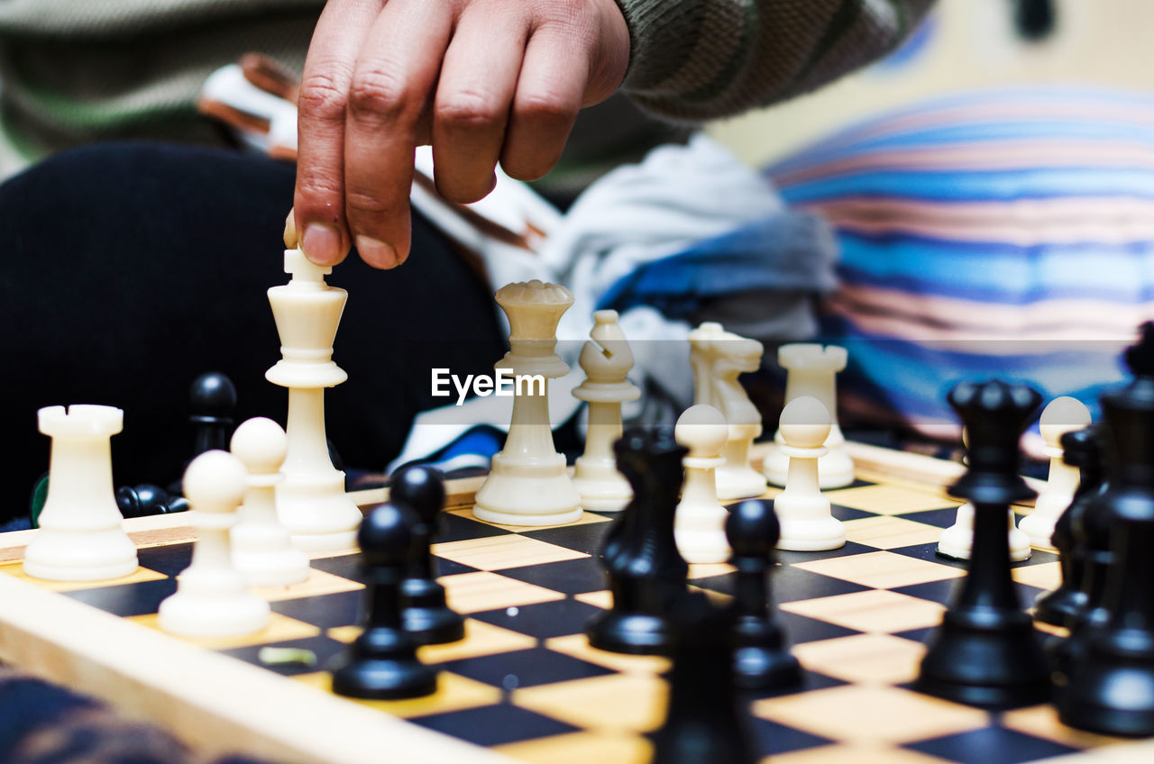 Cropped hand of man playing chess