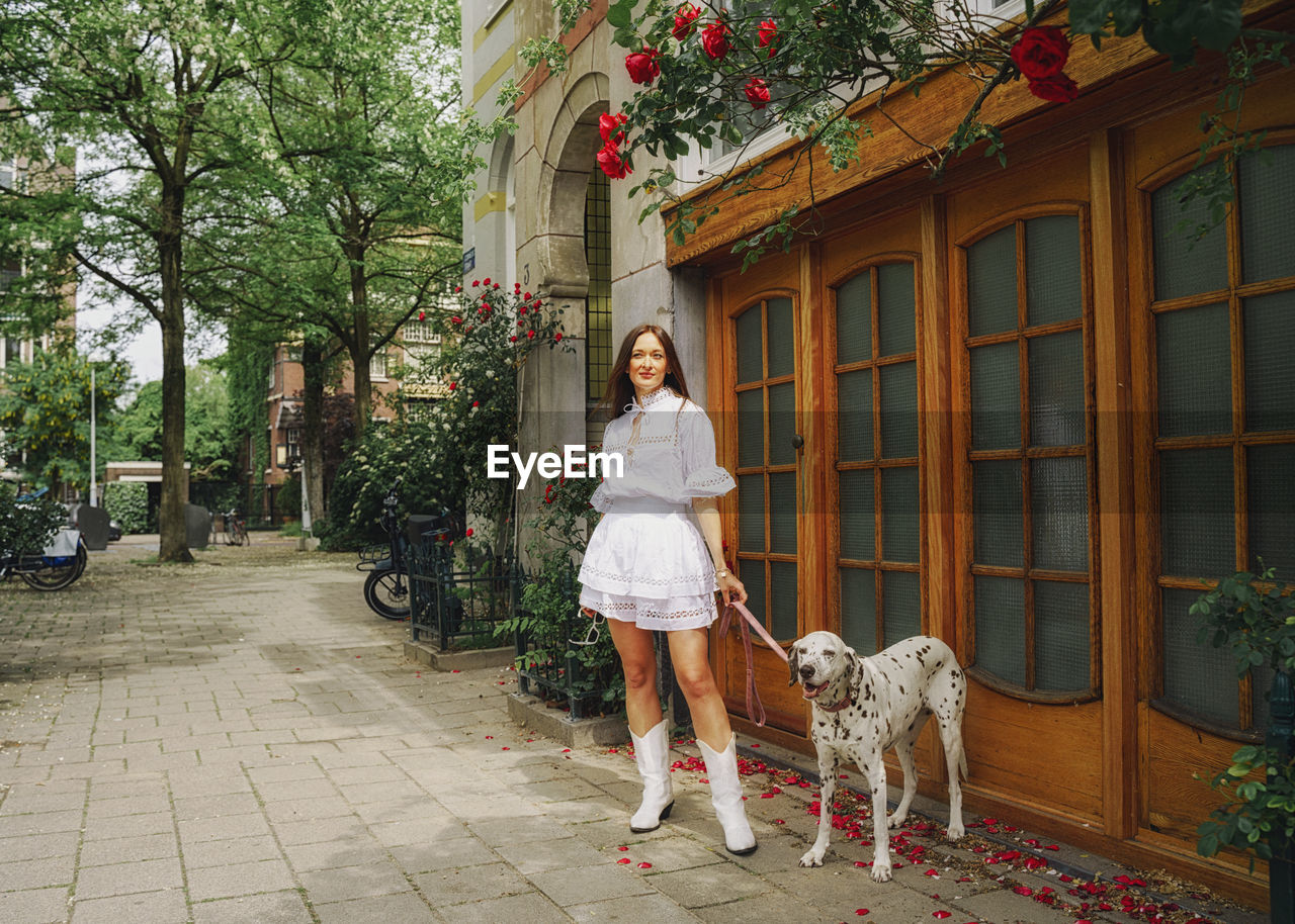 Rear view of woman with dog on street