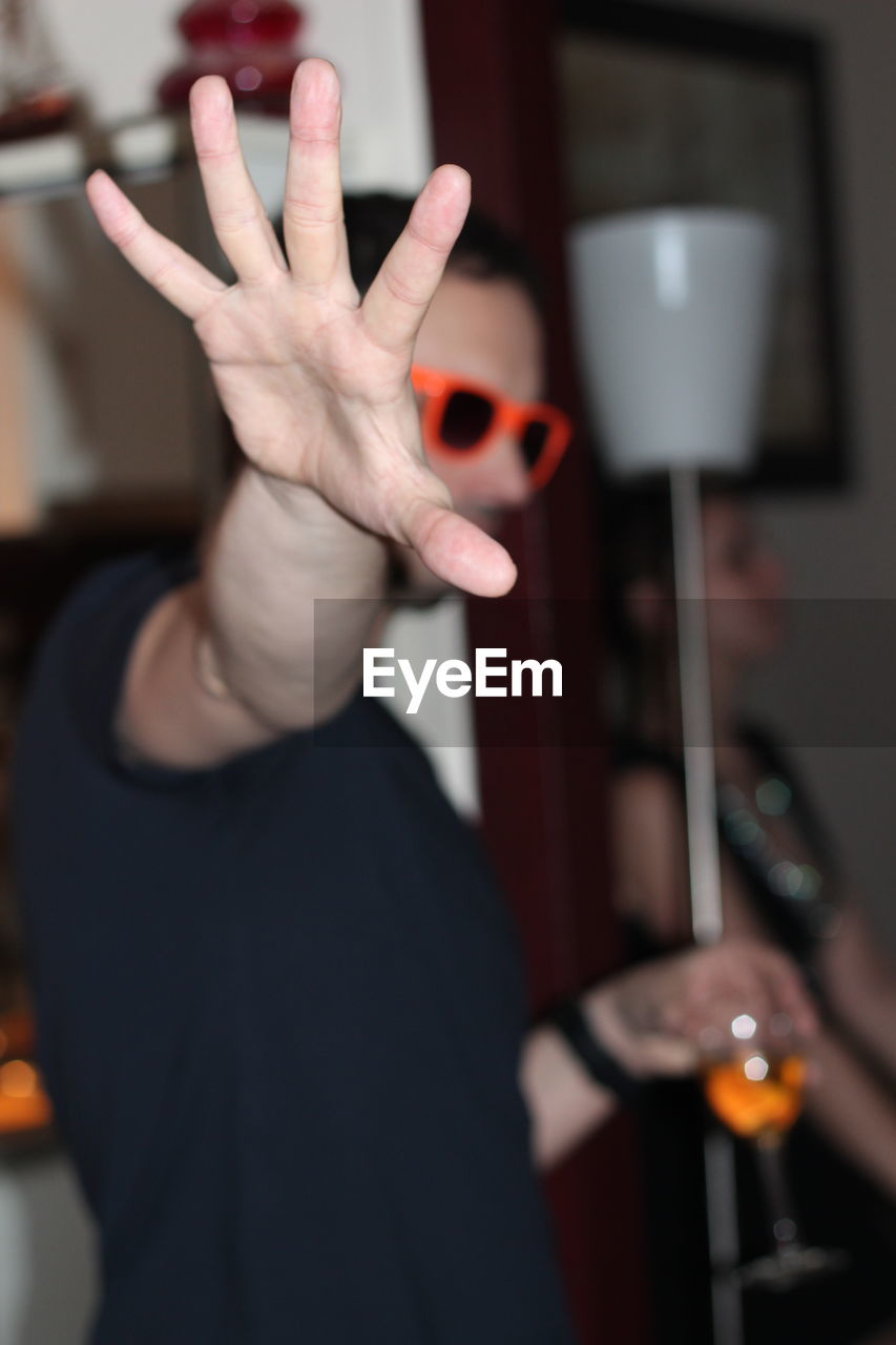 Young man gesturing stop sign at party