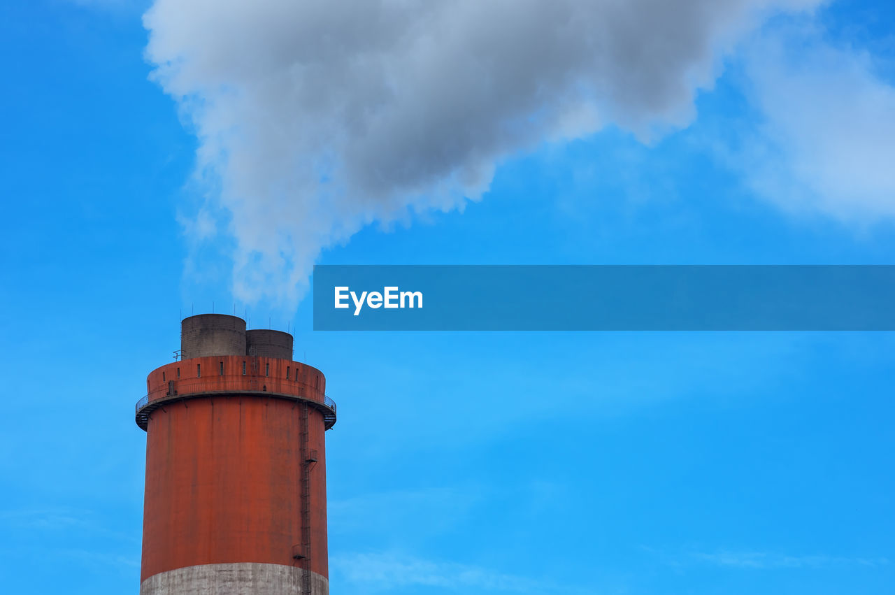 LOW ANGLE VIEW OF SMOKE STACK AGAINST BLUE SKY