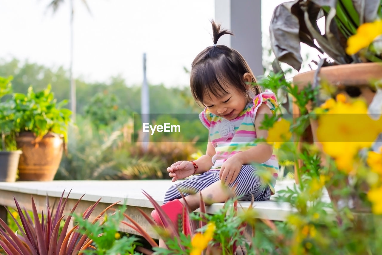 Cute smiling baby girl sitting outdoors