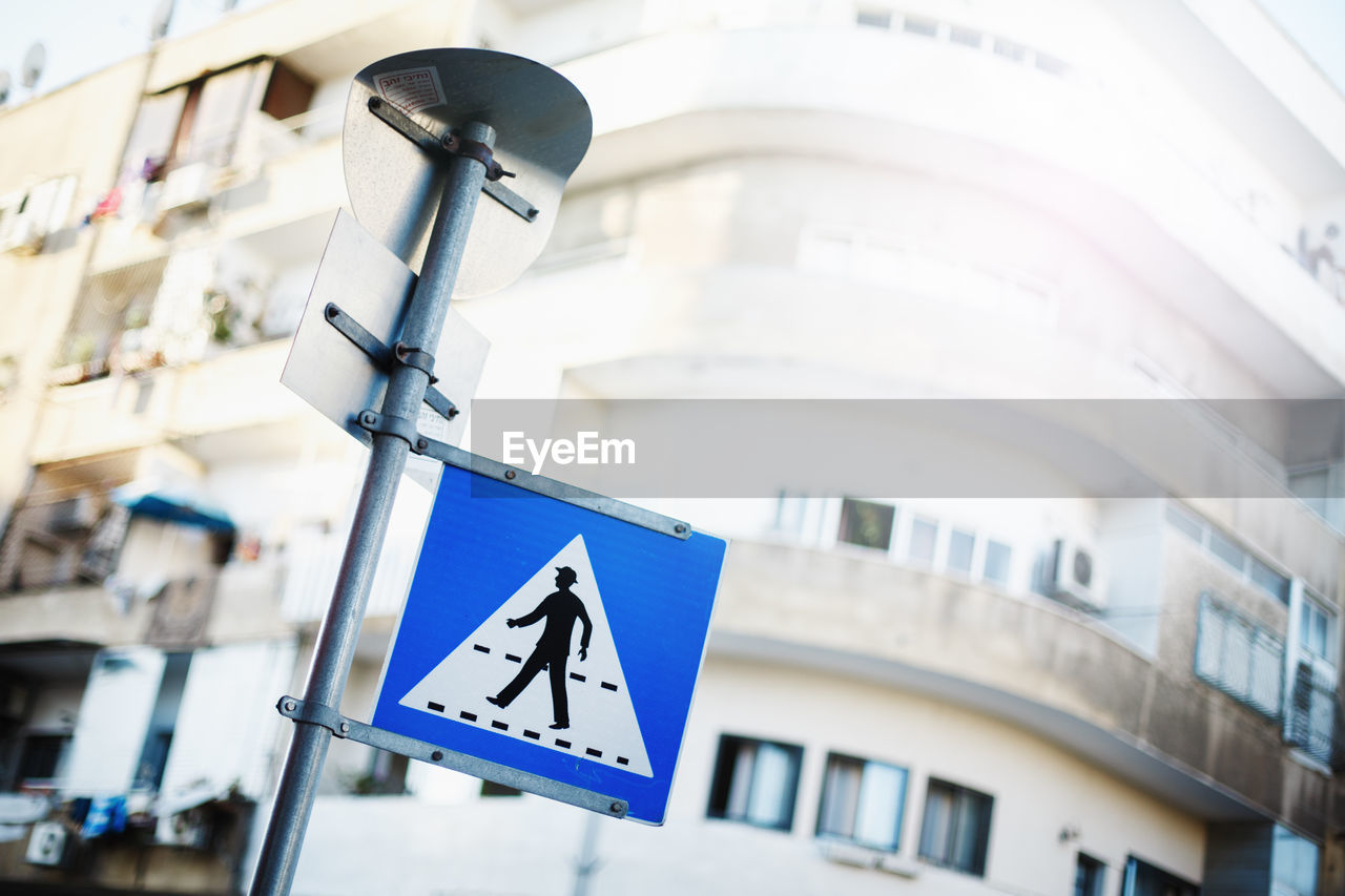 LOW ANGLE VIEW OF ROAD SIGN AGAINST BUILDINGS