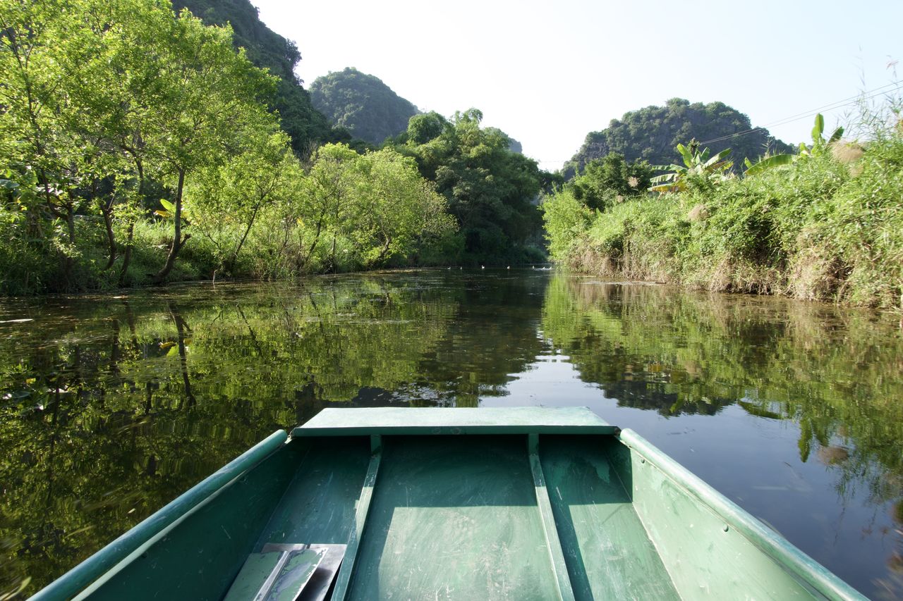 Close-up of boat in lake at forest against sky