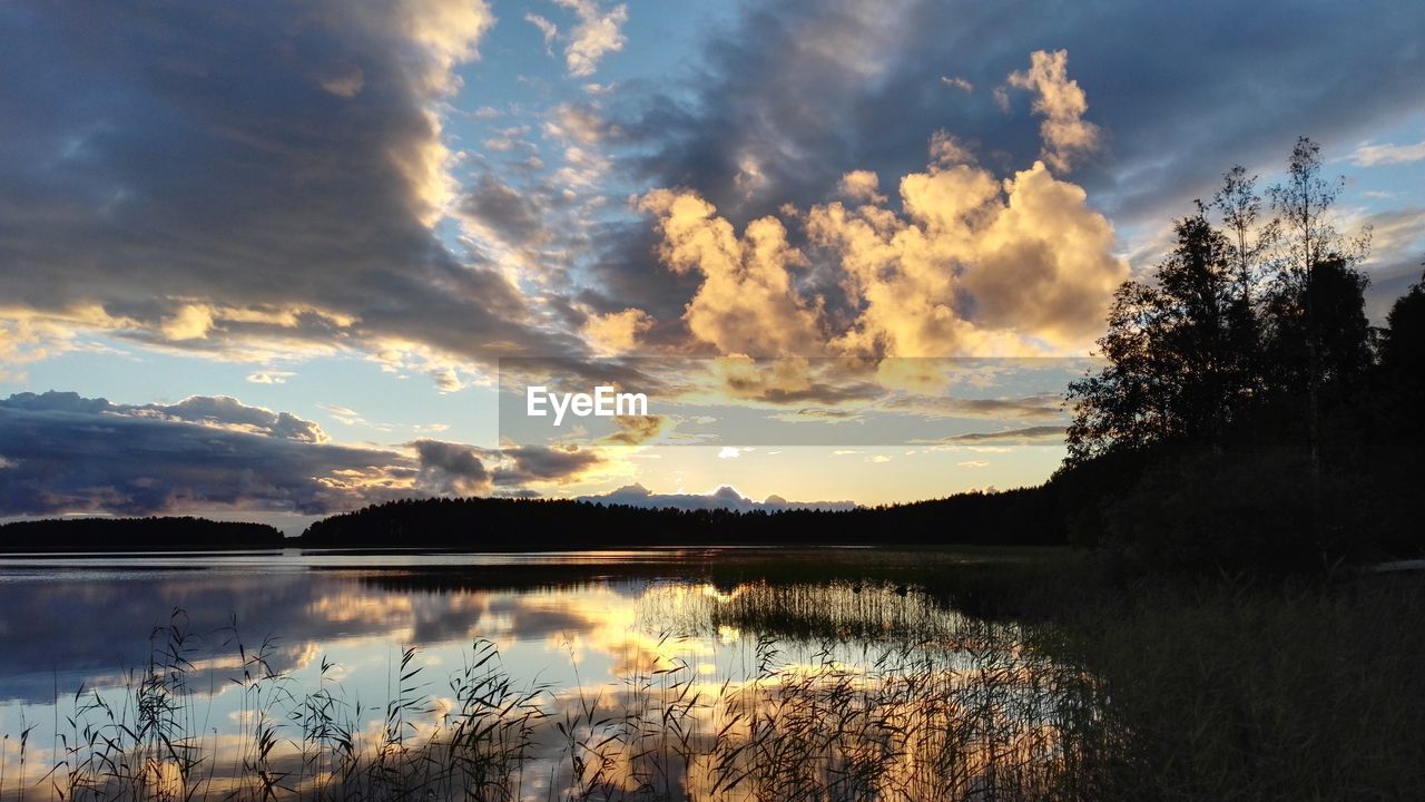 SCENIC VIEW OF CLOUDS OVER LAKE DURING SUNSET