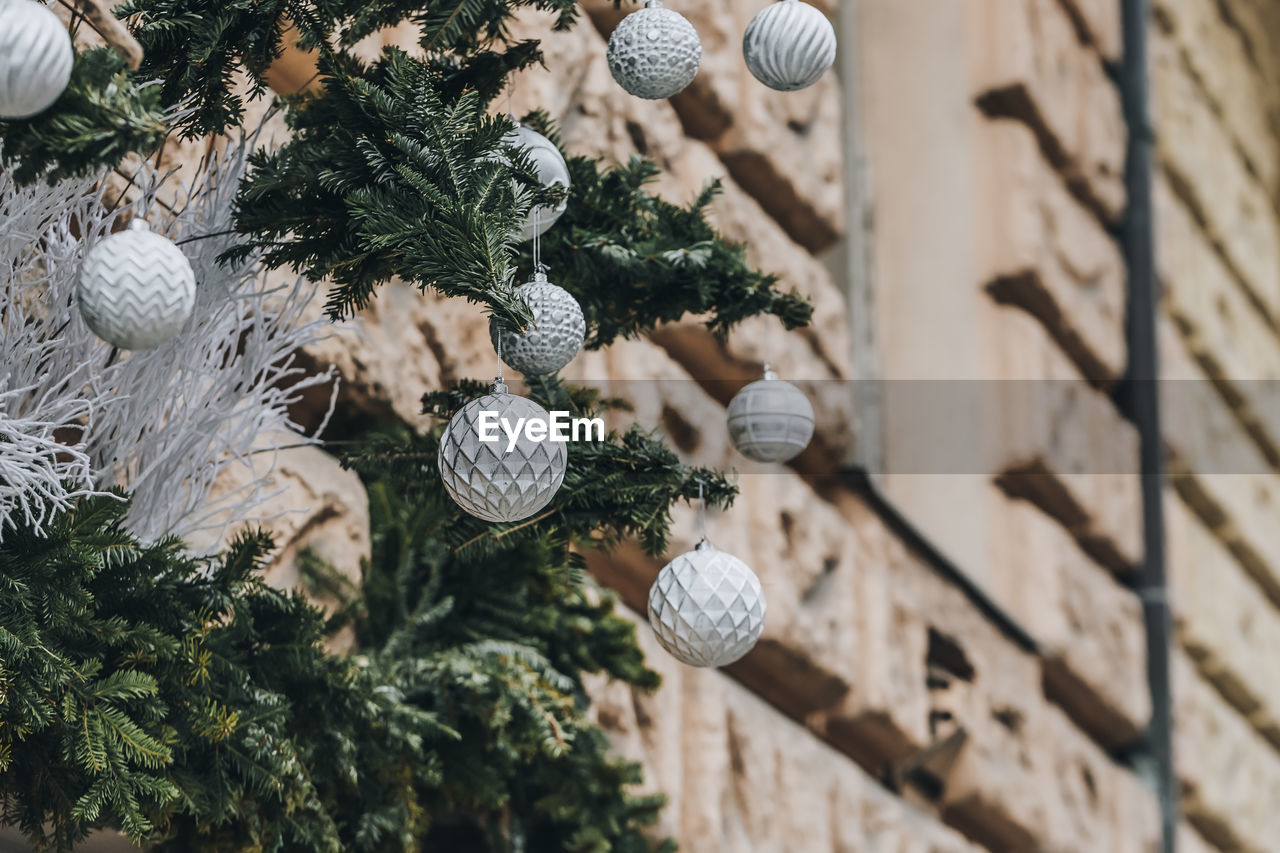 Christmas ourdoor decoration on the building. pine branches and classical christmas balls 