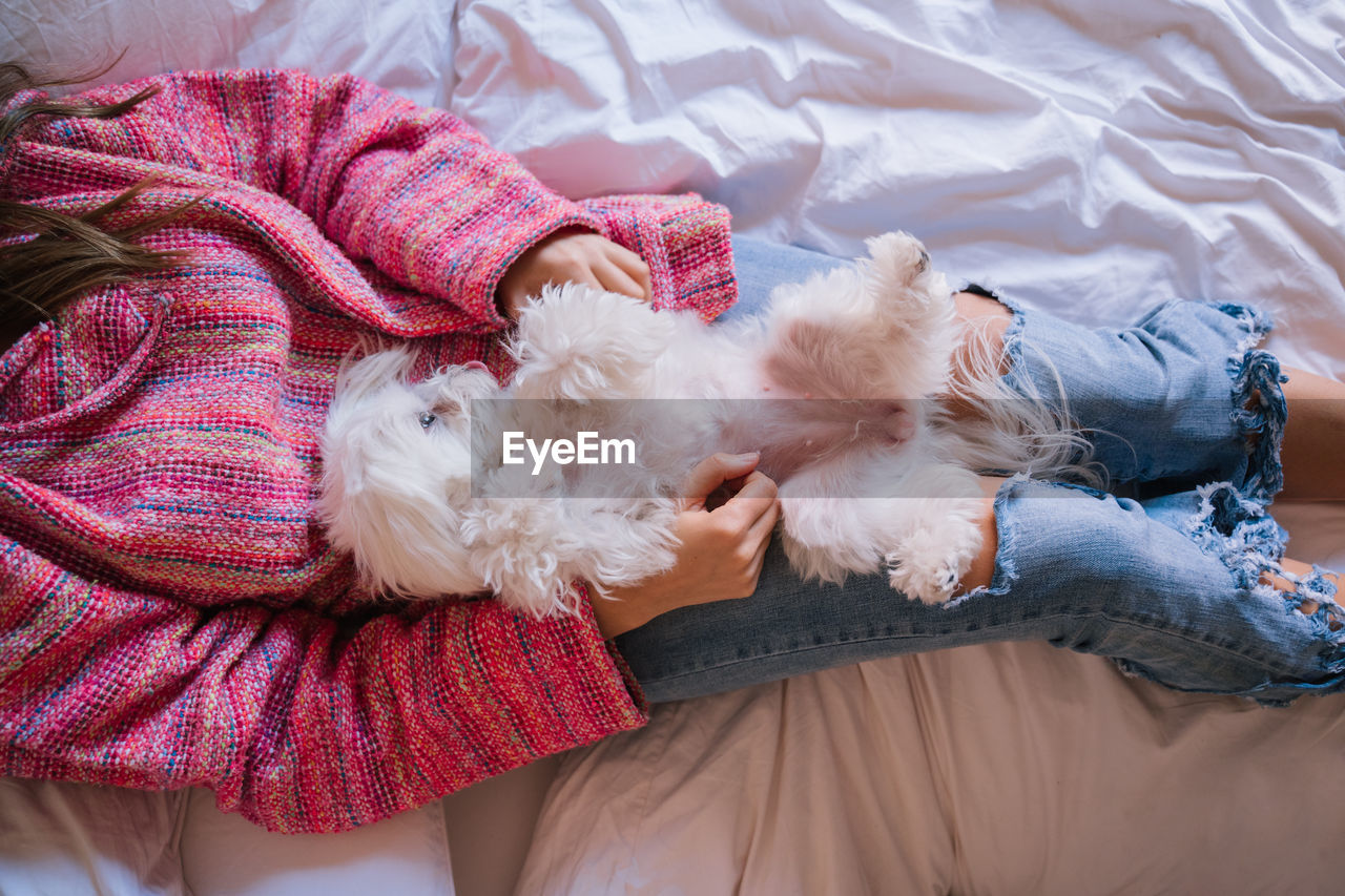 Woman with dog on bed at home