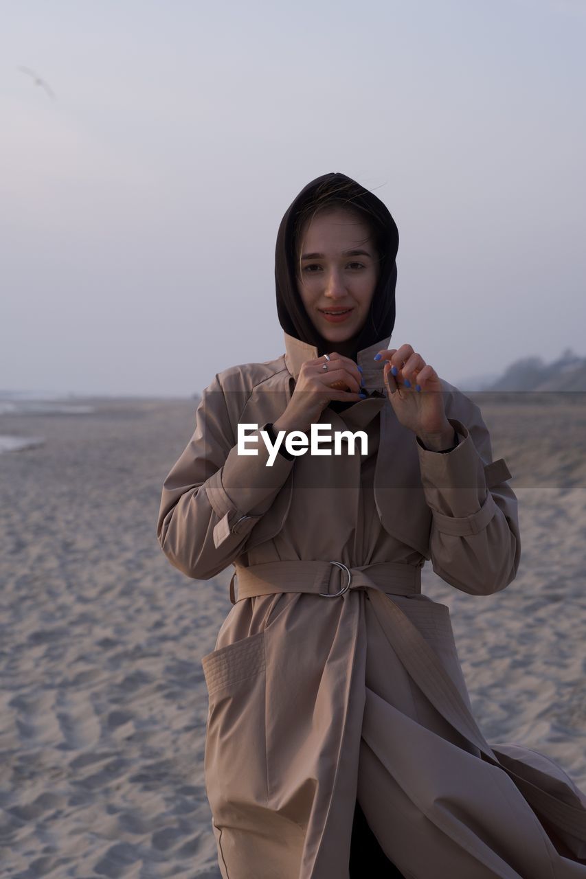 Portrait of young woman standing on beach