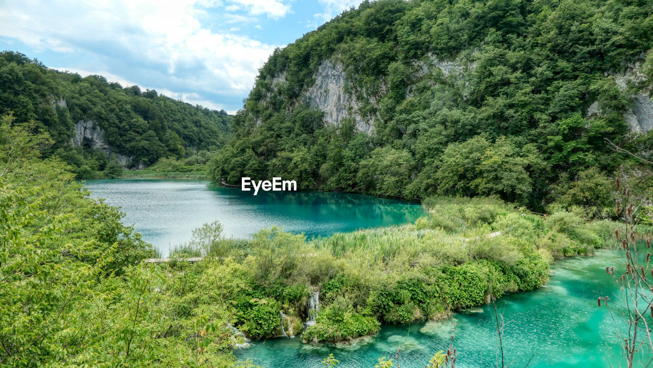 Scenic view of plitvice lakez amidst trees against sky