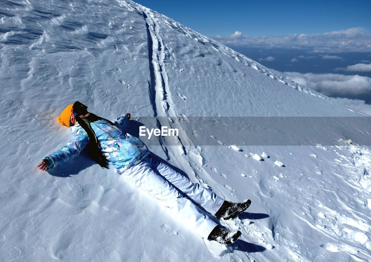 High angle view of person lying on snow 