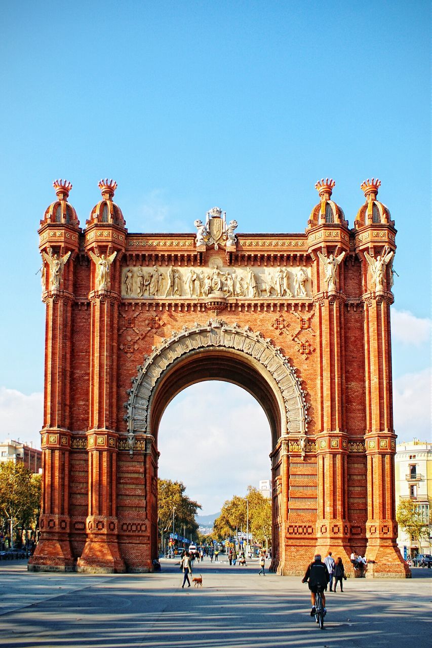 Tourist at arc de triomf against blue sky