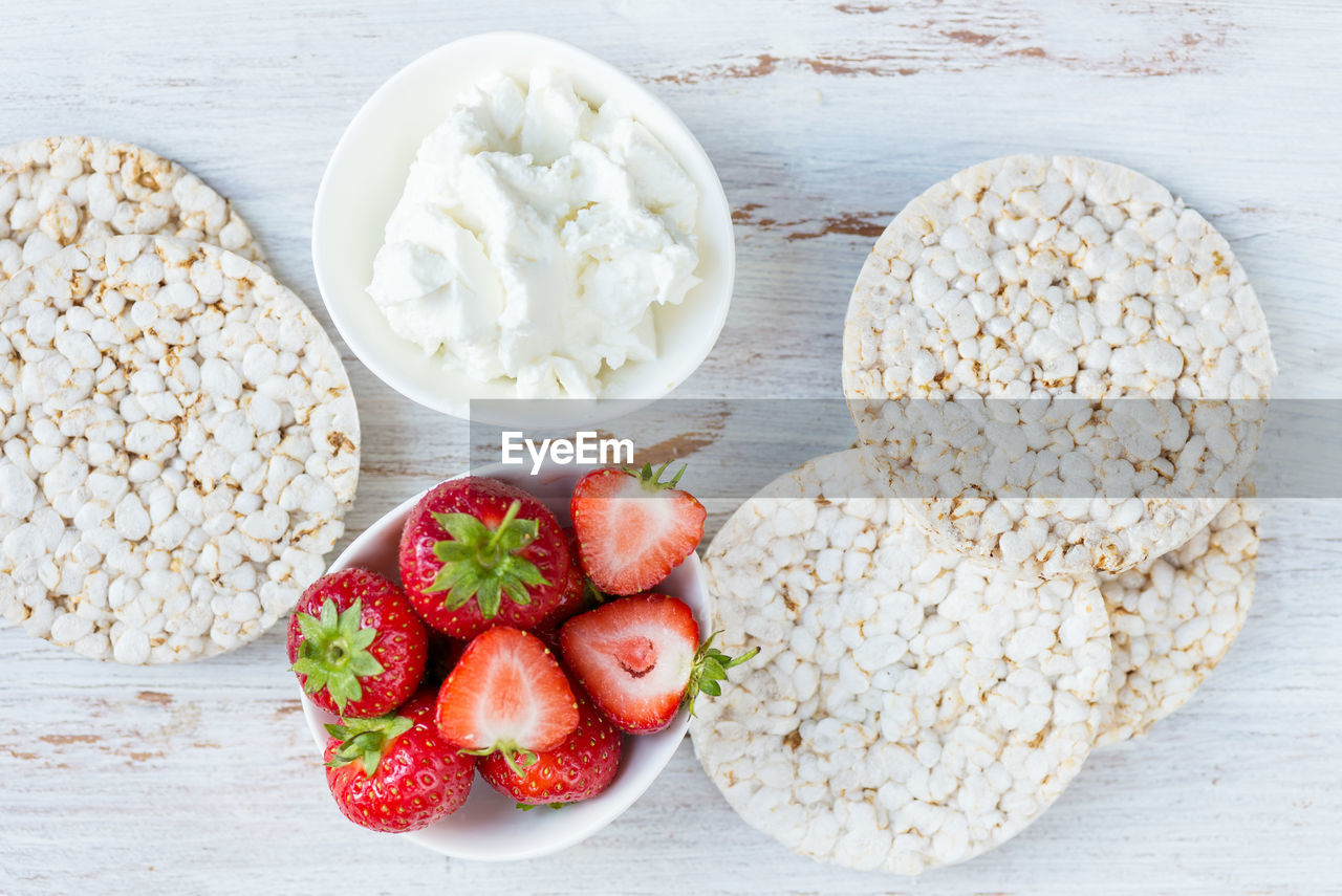 Healthy snack from rice cakes with ingredients nearby such as ricotta cheese and strawberries 