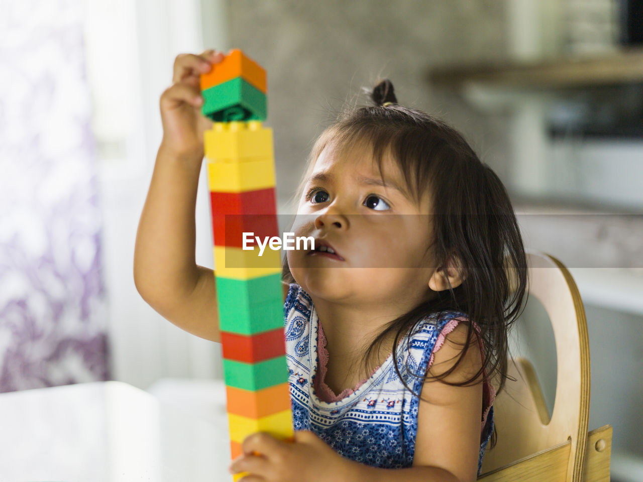 Girl stacking blocks at table