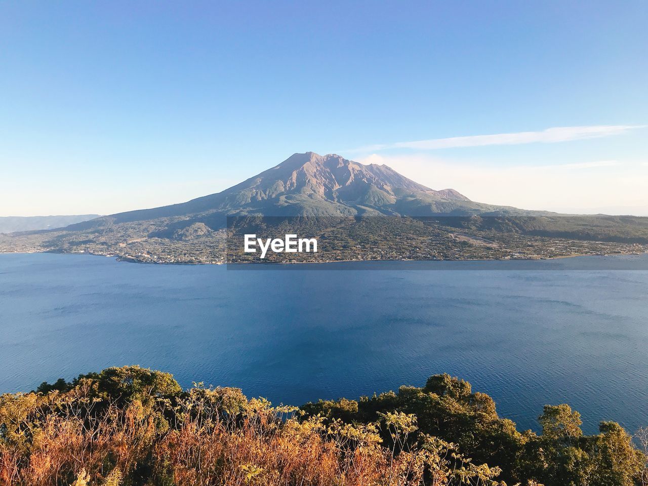 Scenic view of sea and mountains against blue sky