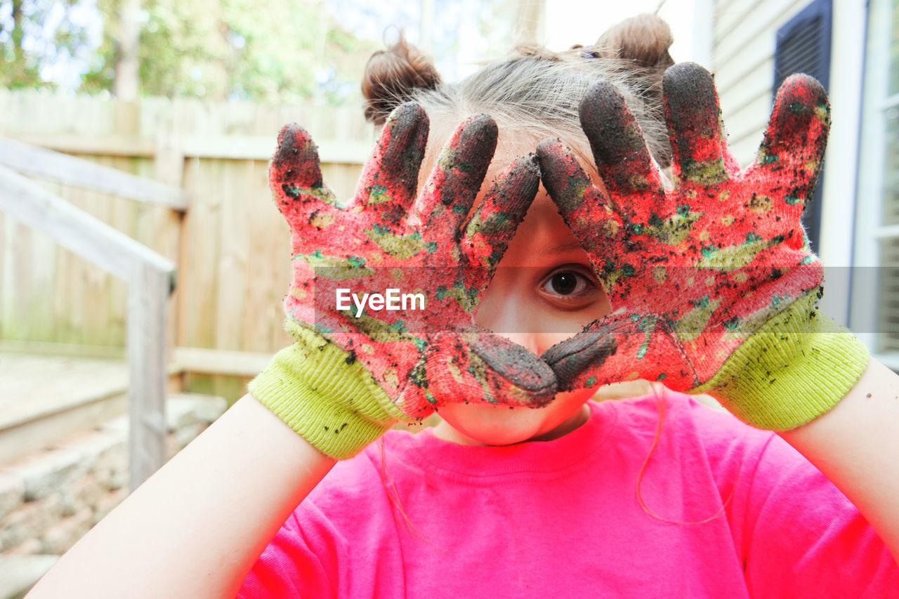 Portrait of cute girl showing dirty hands outdoors