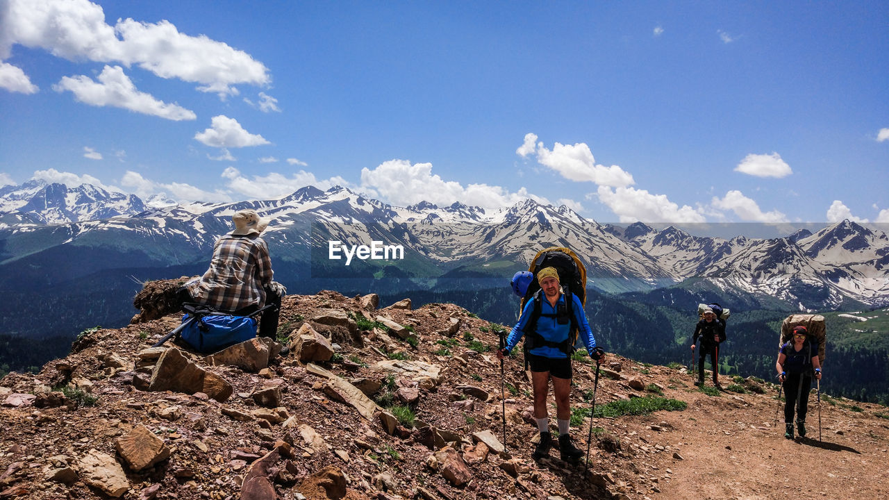 Hikers on mountain peak against sky