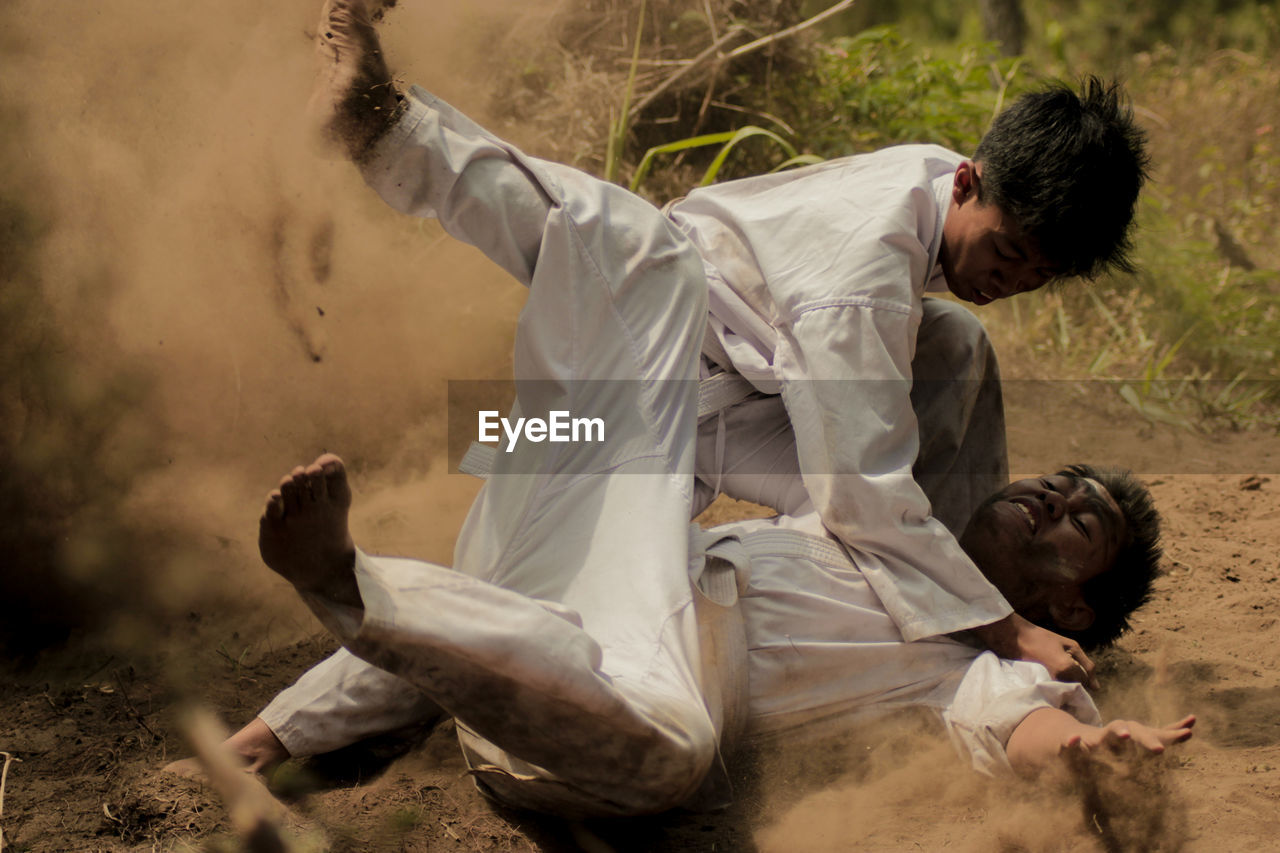 Teenage boys doing martial arts on field