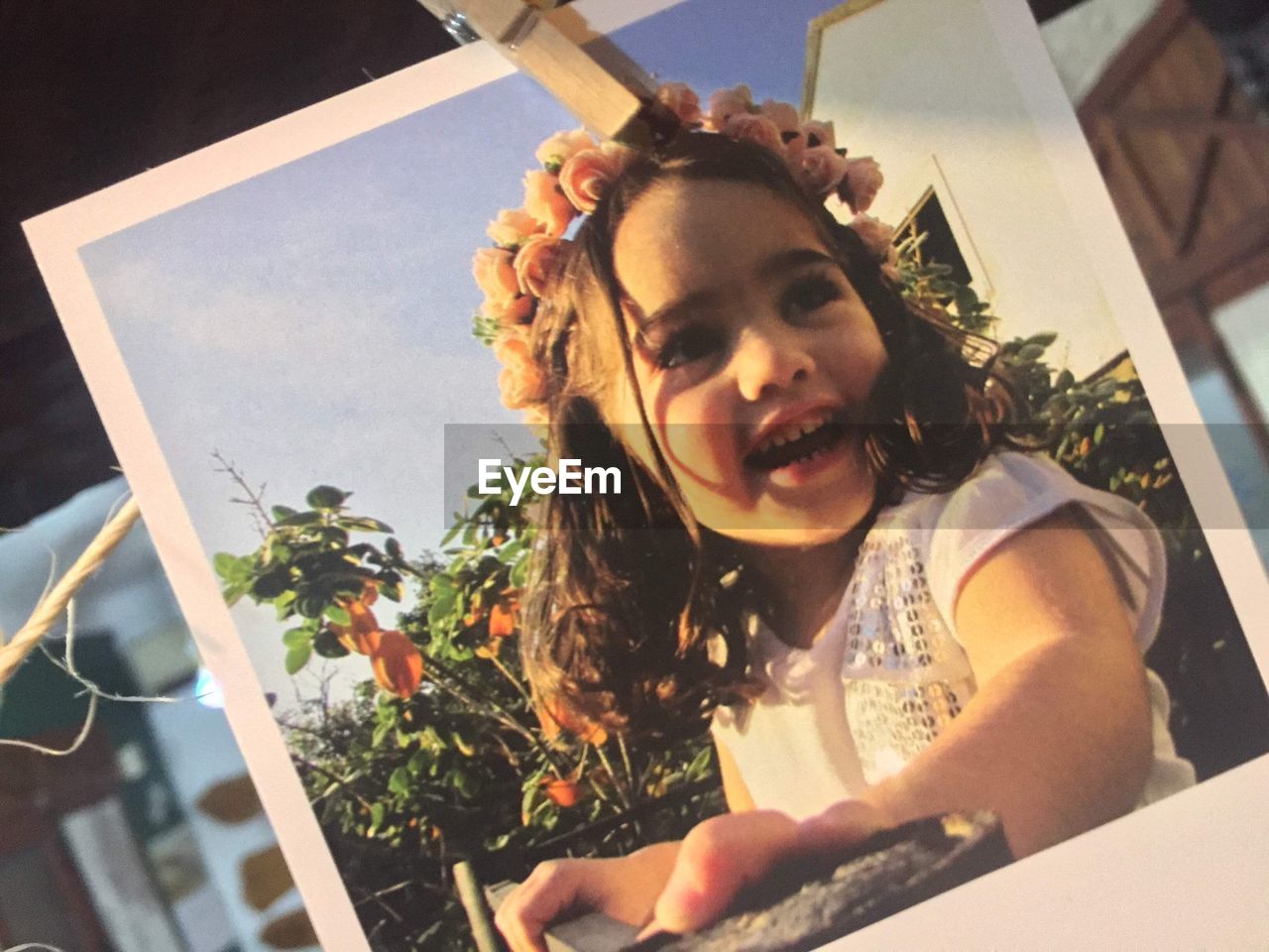 Photograph of girl hanging from clothespin