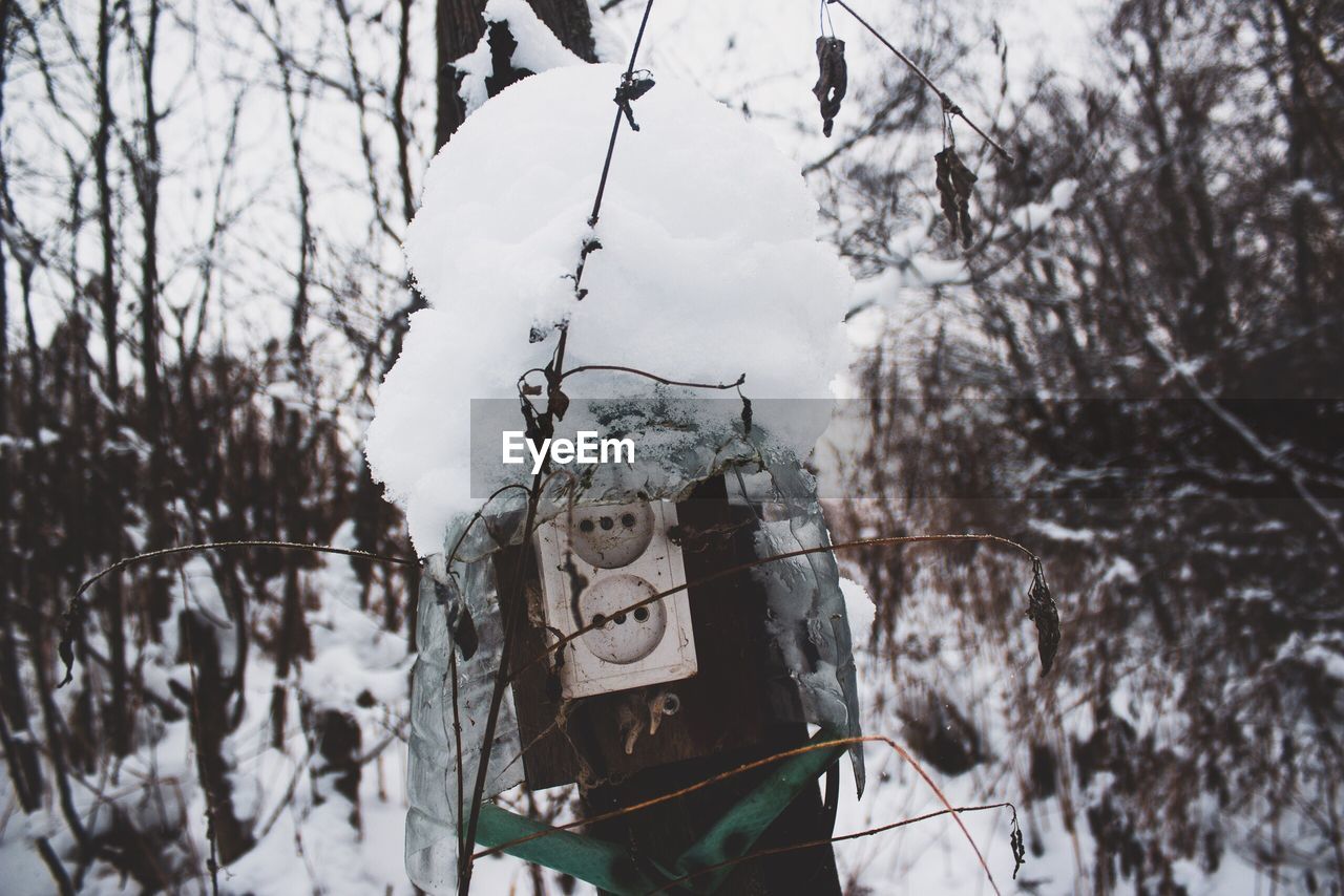 Electrical equipment on snow covered land against sky