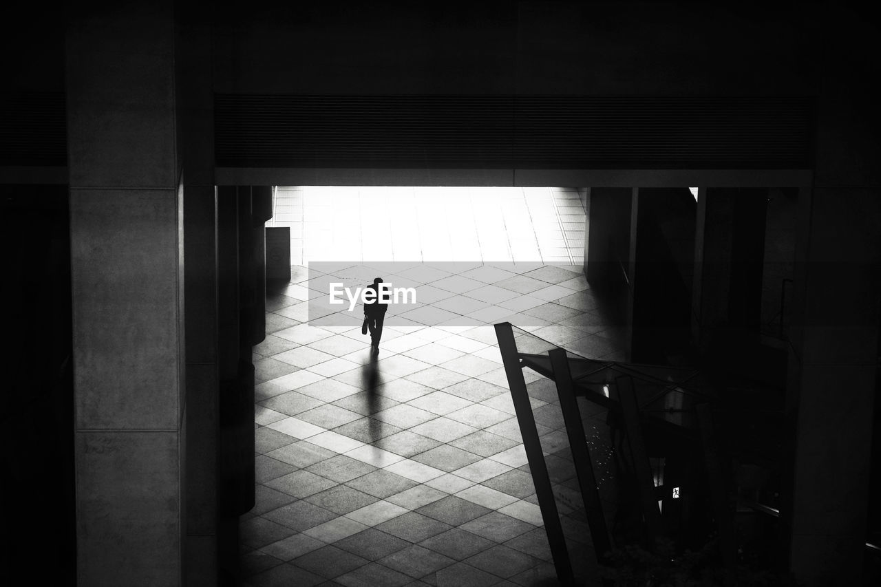 SILHOUETTE OF PERSON STANDING BY DOOR