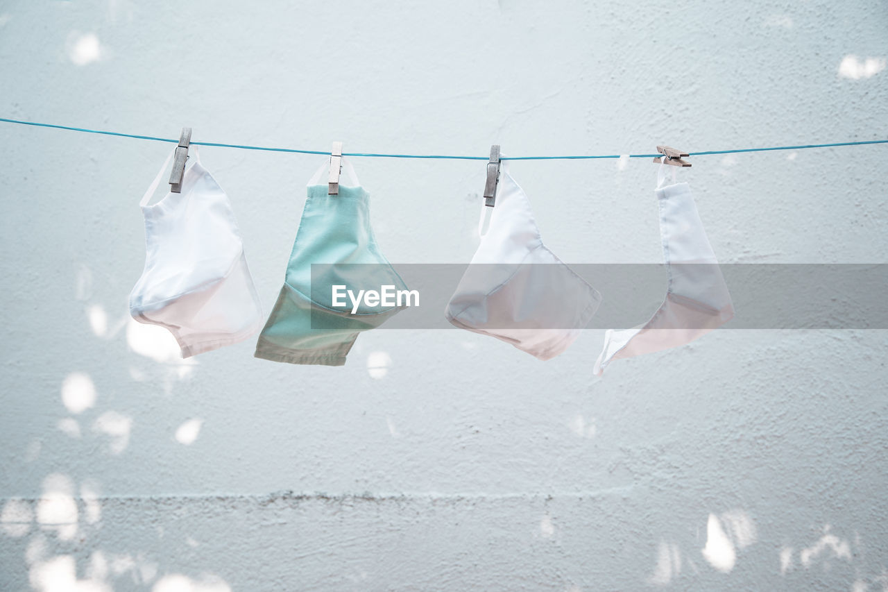 Close-up of clothes drying on clothesline against wall