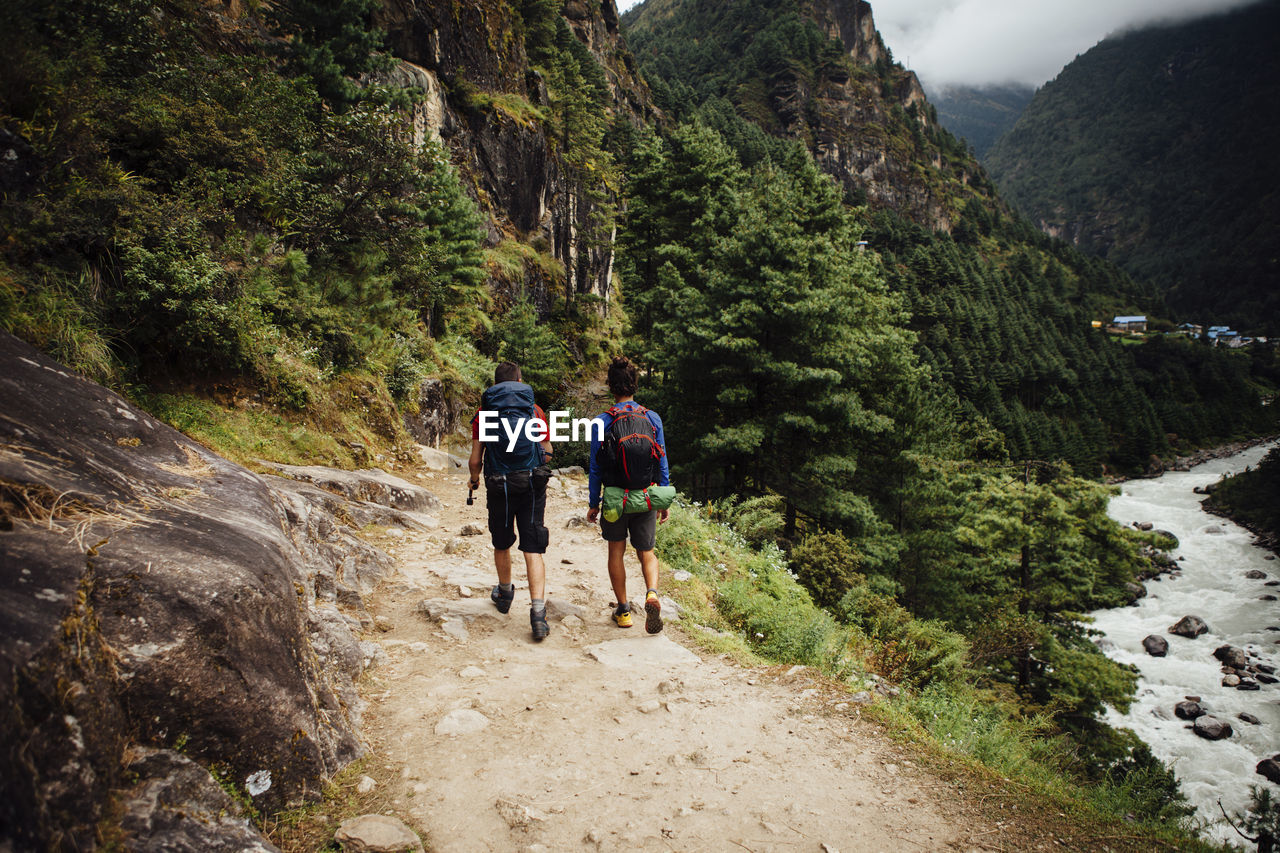 Rear view of friends with backpacks hiking at sagarmatha national park