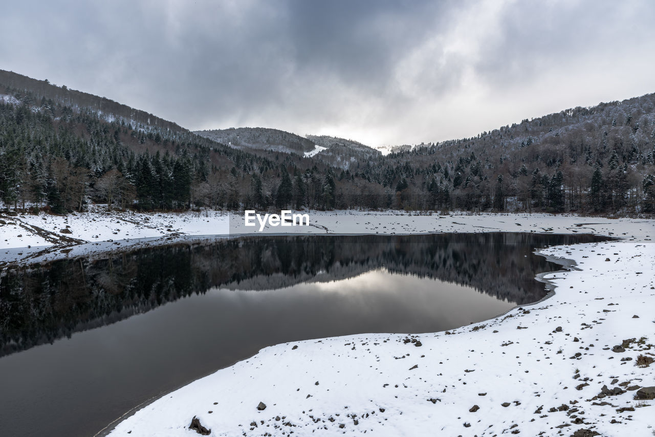 Scenic view of lake by mountains against sky