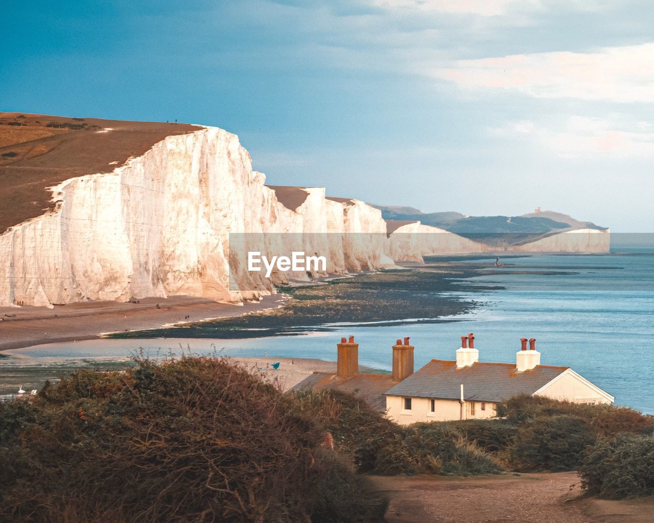 Scenic view of beach and cliffs against sky