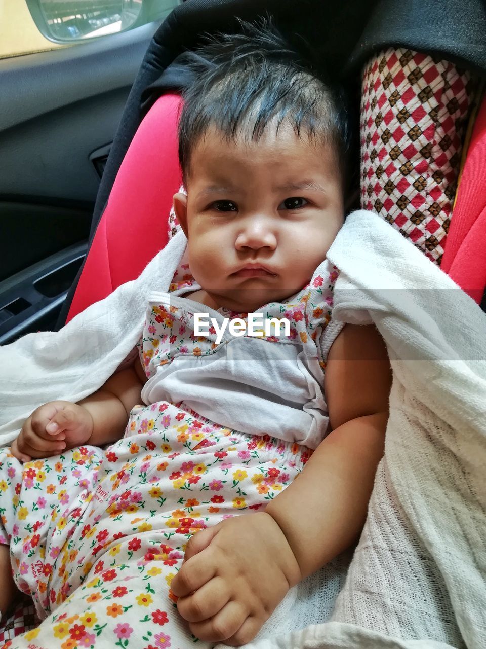 PORTRAIT OF CUTE BABY GIRL IN CAR