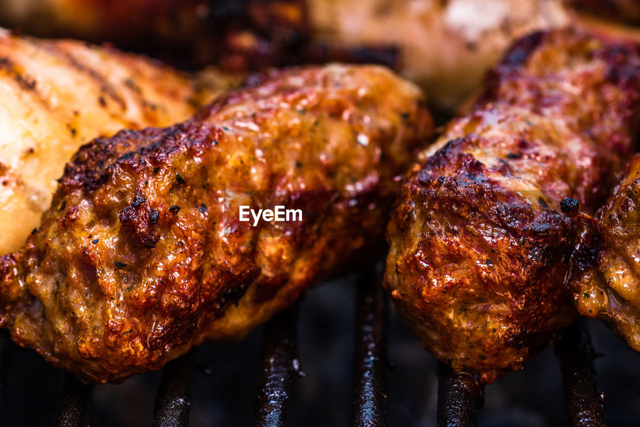 CLOSE-UP OF MEAT COOKING ON BARBECUE GRILL