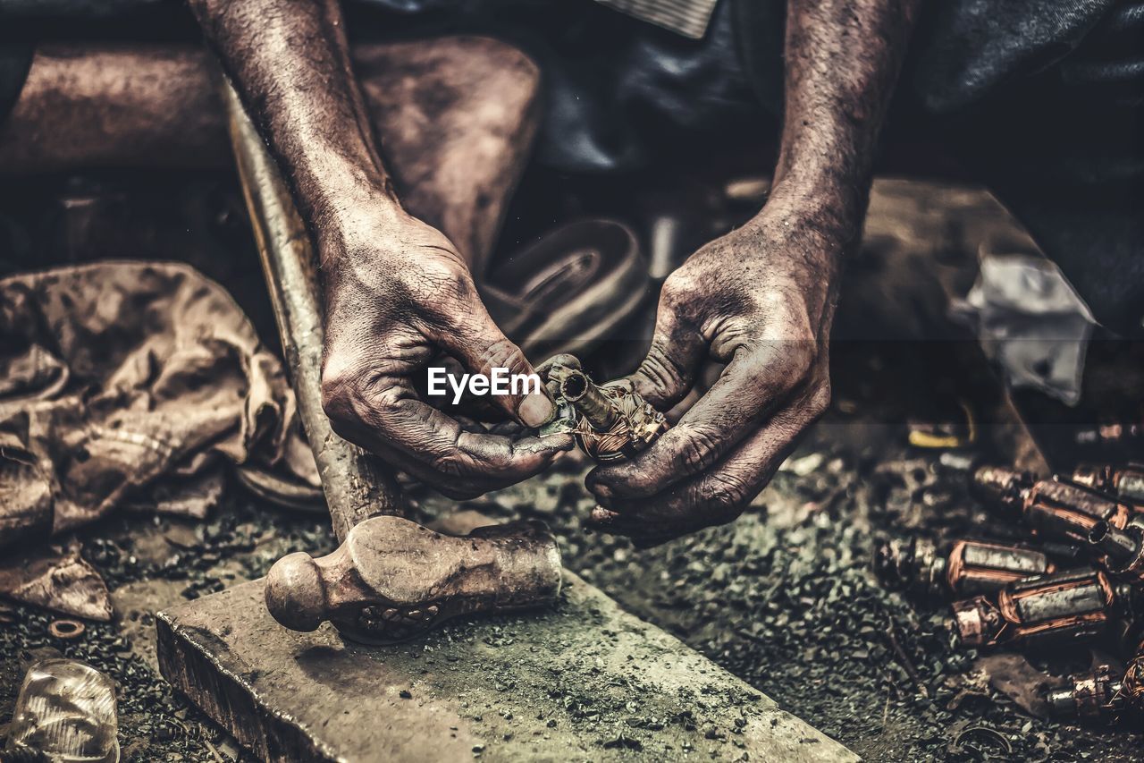 Midsection of worker holding machine part