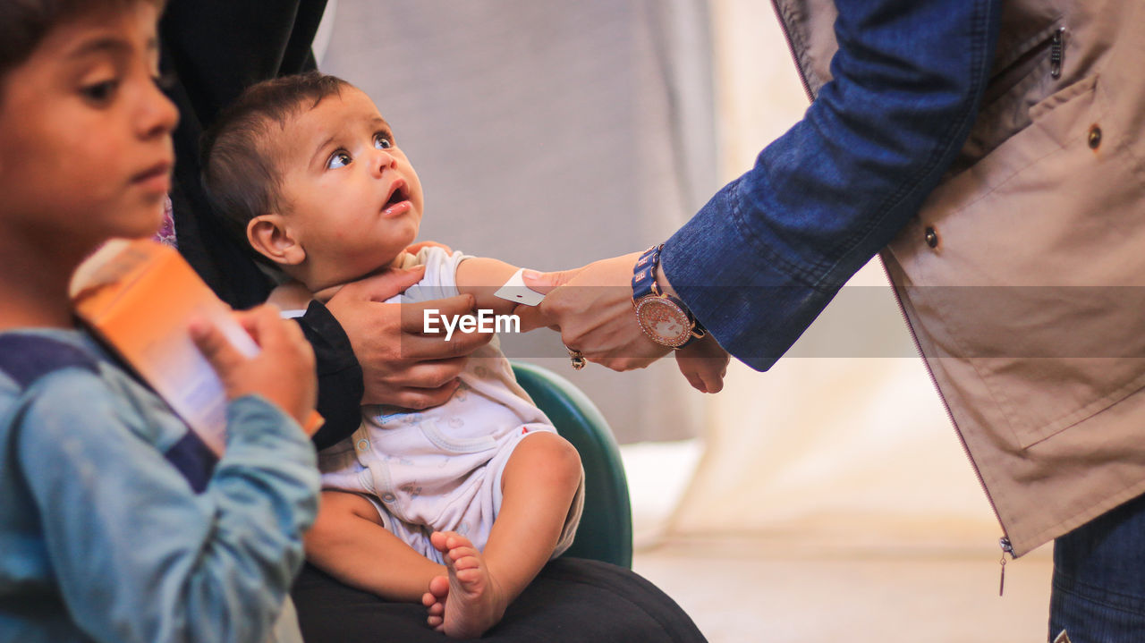 Midsection of man holding baby hand