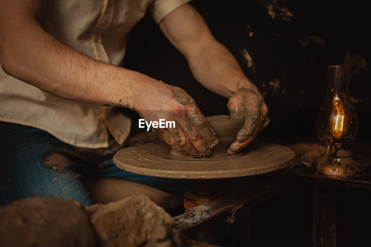 potter's wheel, craft, occupation, hand, art, one person, adult, skill, craftsperson, indoors, working, pottery, wood, men, making, workshop, creativity, person, midsection, expertise, clay, business, holding, spinning