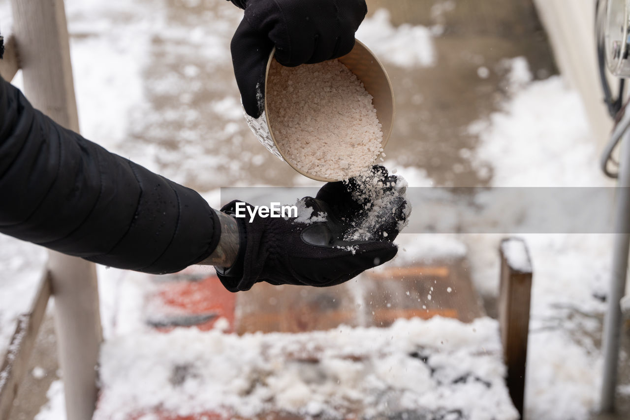 CLOSE-UP OF PERSON WORKING ON SNOW COVERED