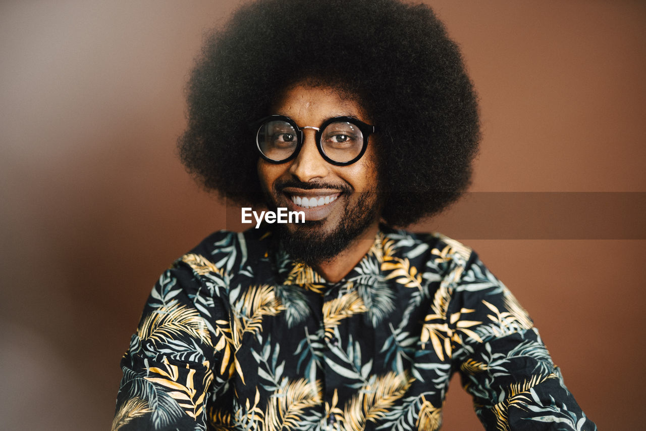 Portrait of smiling man with afro hairstyle in studio