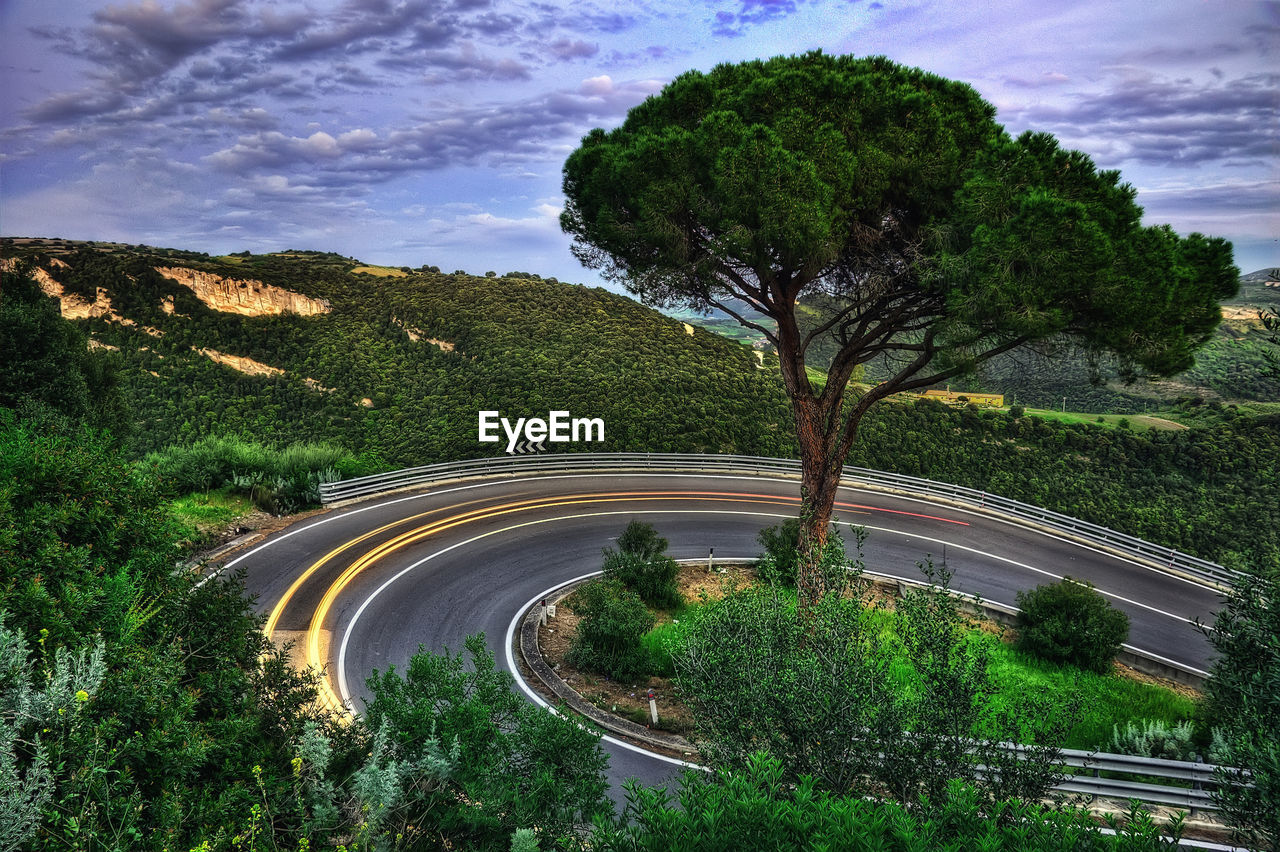 High angle view of road amidst trees against sky