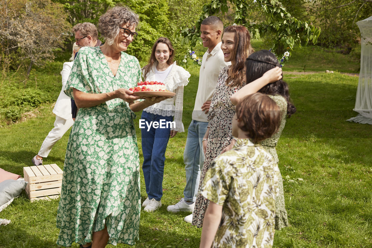 Family celebrating with cake outdoors