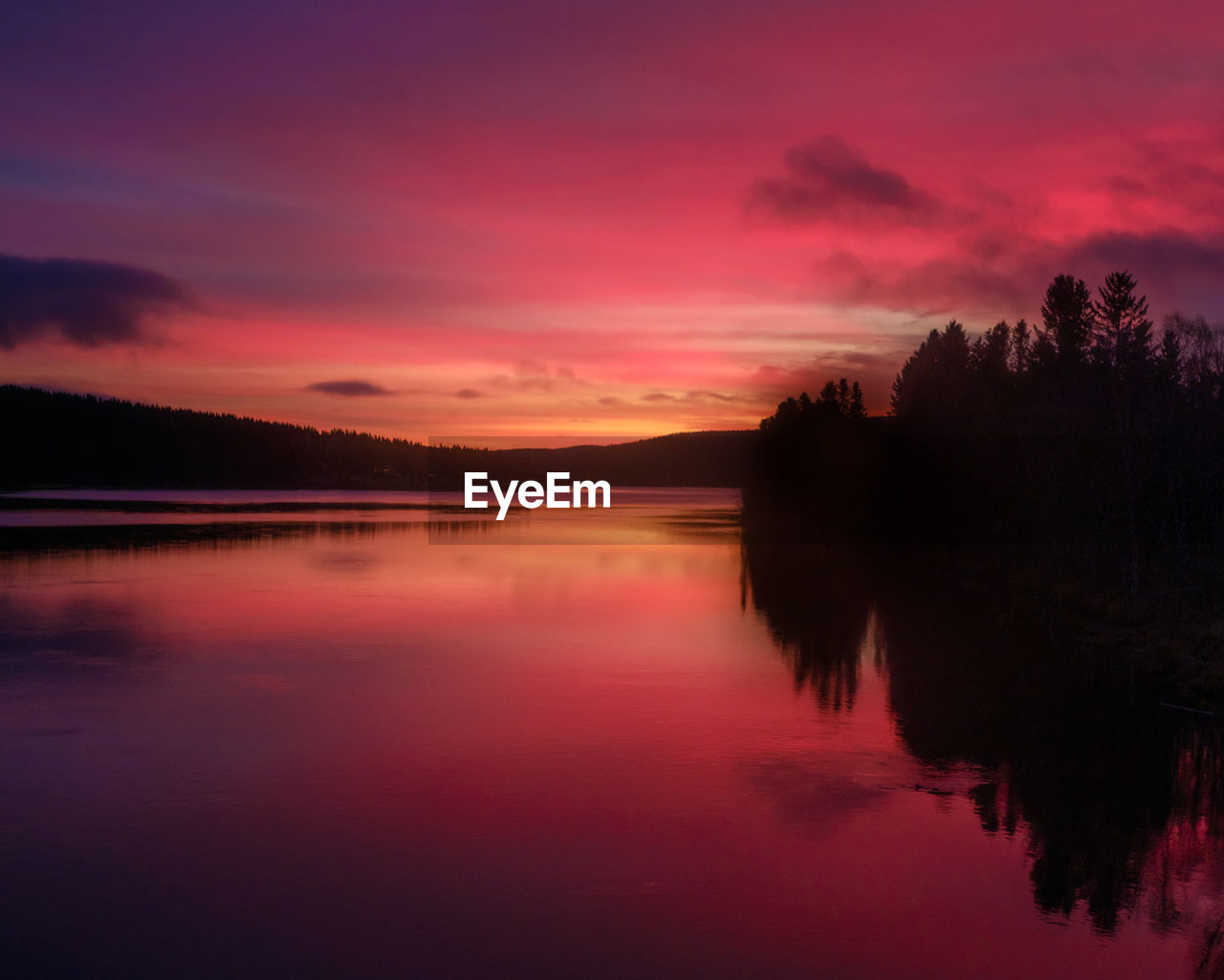 Scenic view of lake against romantic sky at sunset