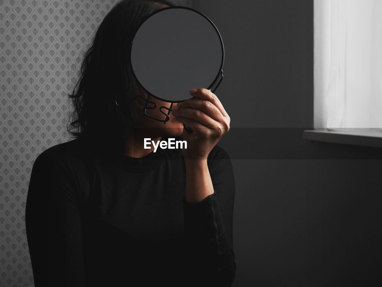 Close-up of woman looking into mirror at home